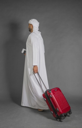 Middle Eastern Businessman walking with carry on|-