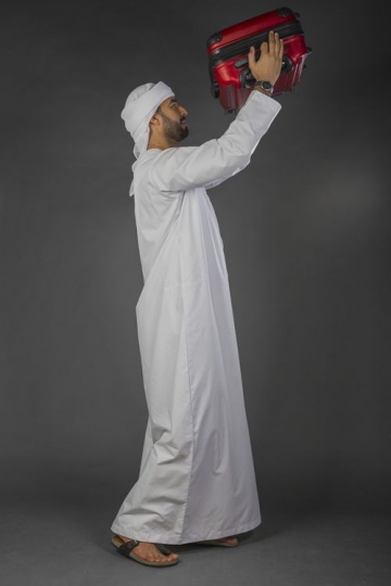 Middle Eastern Businessman lifting up his carry on|-