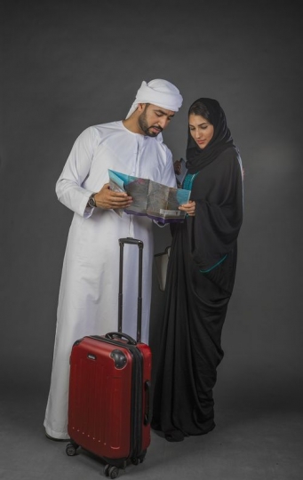 Middle Eastern couple standing and checking the map |-