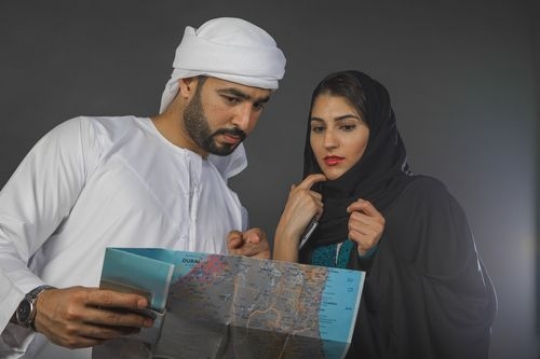 Middle Eastern man and woman looking at the map together|-