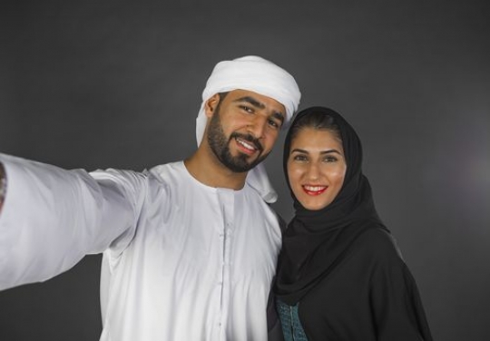 Middle Eastern man and woman taking a selfie together|-