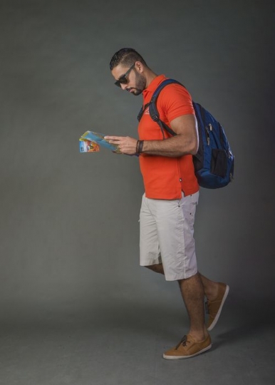 Arab man walking with a map in hand|-