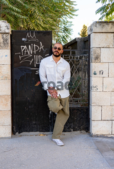 Stylish Man Leaning Against Black Door with Vintage Vibe