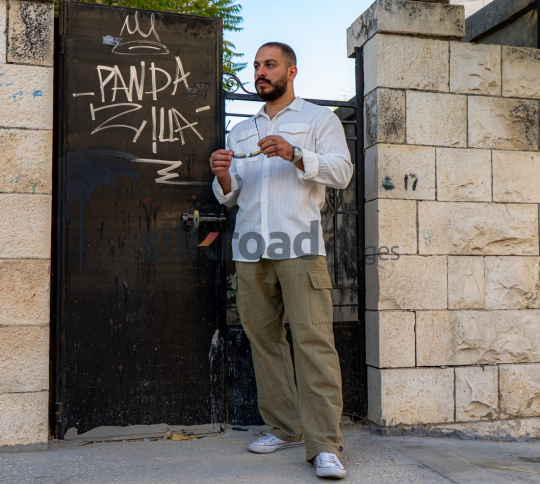 Stylish Man Leaning Against Black Door with Vintage Vibe