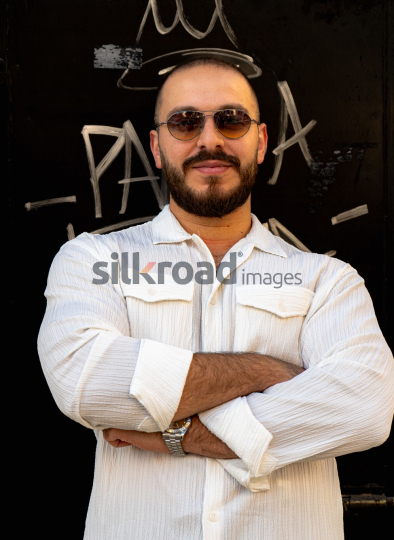 Stylish Man Leaning Against Black Door with Vintage Vibe
