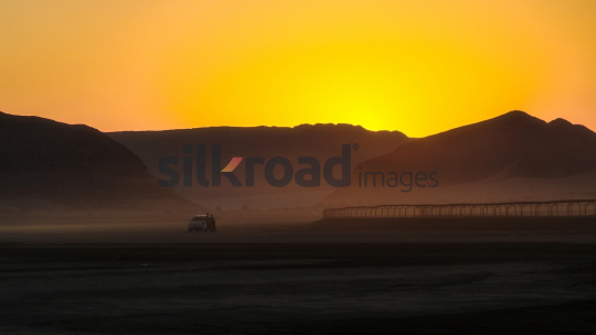 Sunrise Over Wadi Rum Desert with Tourists and Vehicle, Jordan