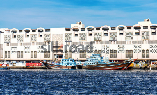 Traditional Dhow Boats at Dubai Creek Near Historical Architecture