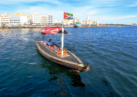 Traditional Wooden Boat on Dubai Creek with Skyline View