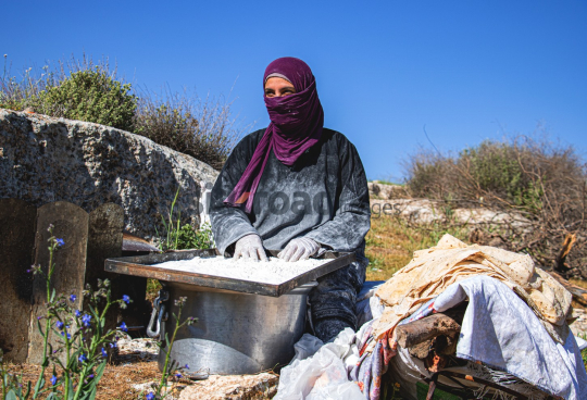 Woman Sifting Flour for Traditional Bread Preparation in the Countryside
