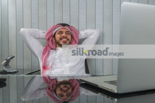 Businessman sitting at his desk smiling