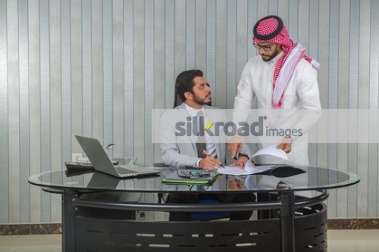 Middle Eastern man signing the paper from the Businessman