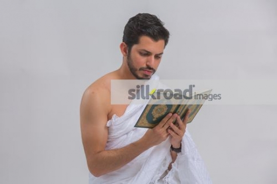 Young Middle Eastern man reading the holy book|