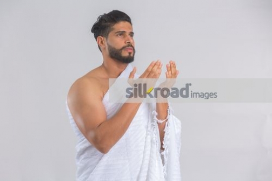 Medium shot of a Middle Eastern man dressed in the religious attire|