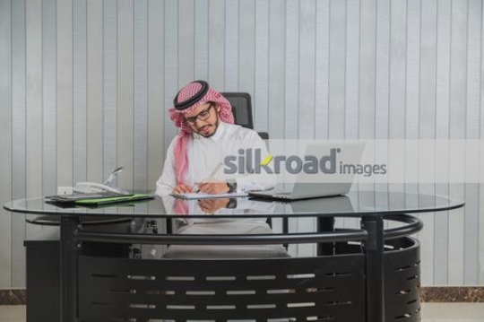 Middle Eastern Businessman sitting at his desk working|