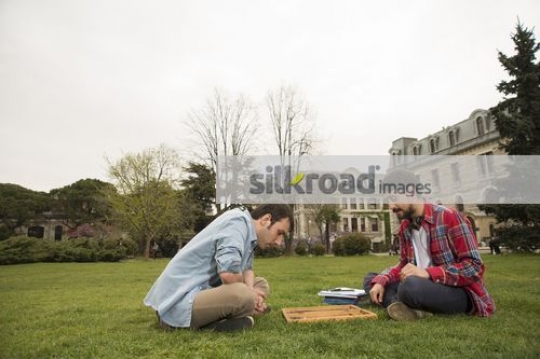 Men sitting on the grass together|